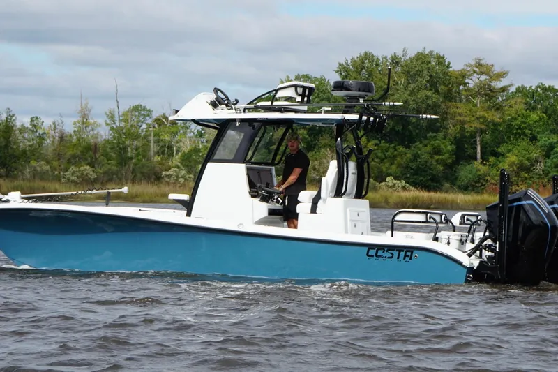  Yacht Photos Pics 2025 Costa Custom Boats 264 HC cruising on a river with lush green trees in the background.