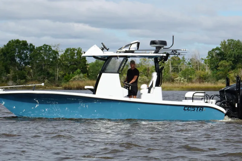  Yacht Photos Pics 2025 Costa Custom Boats 264 HC cruising on a scenic waterway with lush greenery.
