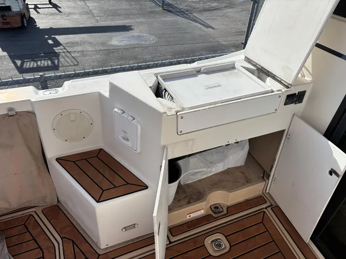 Y Knot Yacht Photos Pics 2017 Cutwater C-28 Deluxe boat interior with storage compartment and wooden flooring.