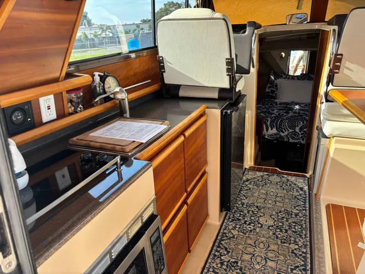 Y Knot Yacht Photos Pics 2017 Cutwater C-28 Deluxe interior with kitchen, seating, and cozy cabin.