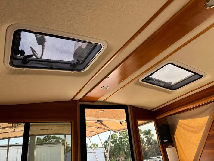 Y Knot Yacht Photos Pics Interior view of 2017 Cutwater C-28 Deluxe boat with skylights and wooden trim.