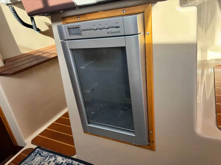Y Knot Yacht Photos Pics Built-in Dometic fridge on 2017 Cutwater C-28 Deluxe boat, featuring wood trim and digital display.