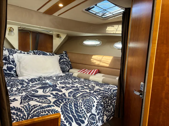 Y Knot Yacht Photos Pics Cozy cabin interior of 2017 Cutwater C-28 Deluxe with patterned bedding and natural light.