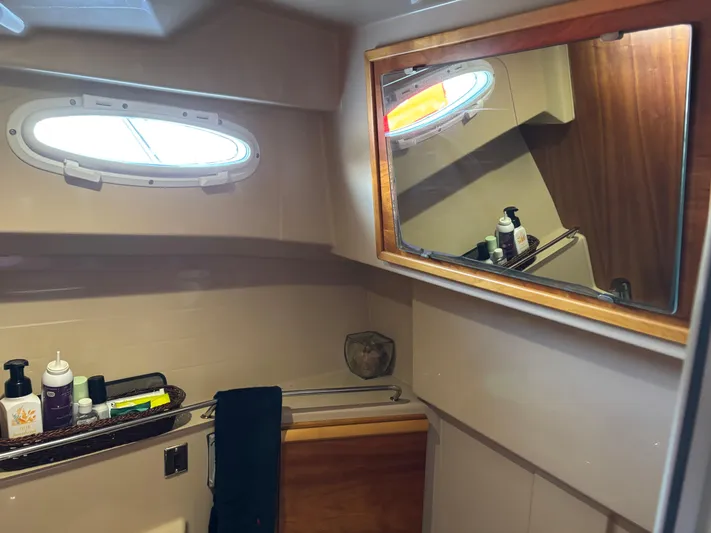 Y Knot Yacht Photos Pics Bathroom interior of 2017 Cutwater C-28 Deluxe boat with mirror and toiletries.