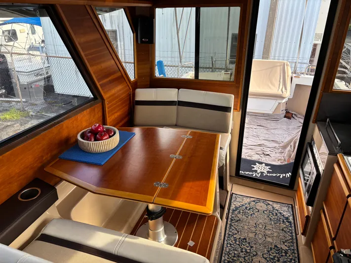 Y Knot Yacht Photos Pics Interior of 2017 Cutwater C-28 Deluxe boat with wooden table and seating area.