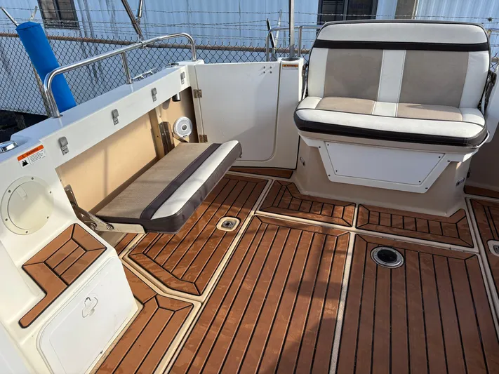 Y Knot Yacht Photos Pics 2017 Cutwater C-28 Deluxe boat interior with wood flooring and cushioned seating.