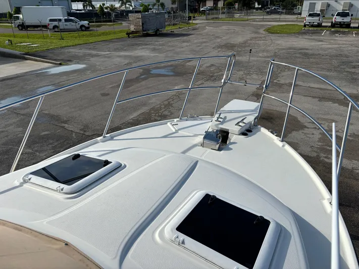 Y Knot Yacht Photos Pics 2017 Cutwater C-28 Deluxe boat deck with hatches and railing in a parking area.