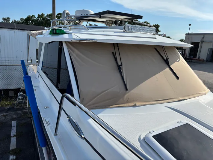 Y Knot Yacht Photos Pics 2017 Cutwater C-28 Deluxe boat with covered windshield, docked outdoors.