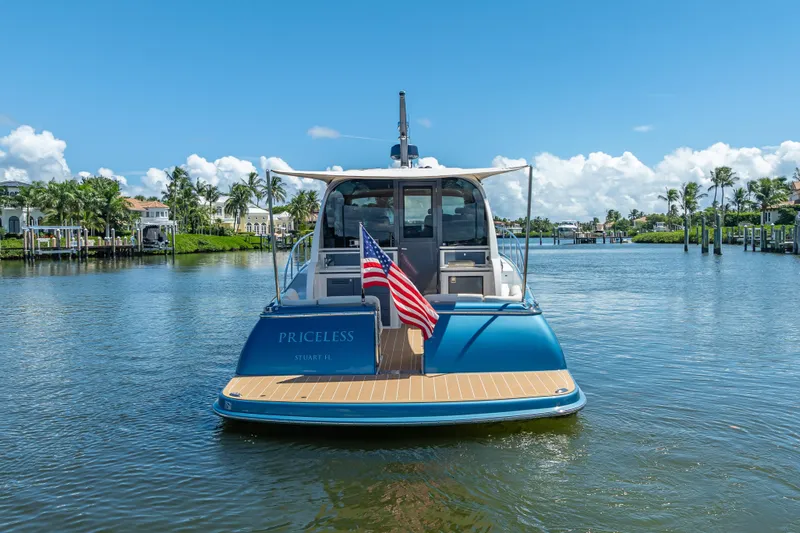 Priceless Yacht Photos Pics 2019 Palm Beach Motor Yachts GT50 on water, rear view with American flag.