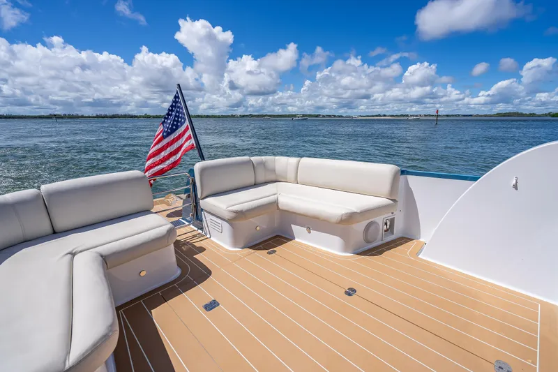 Priceless Yacht Photos Pics 2019 Palm Beach Motor Yachts GT50 deck with seating, American flag, and ocean view.