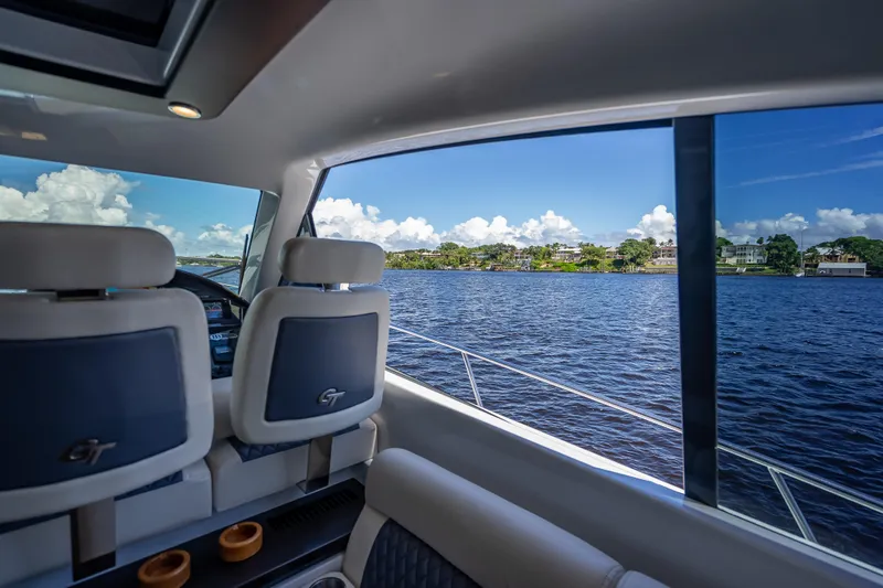 Priceless Yacht Photos Pics Interior view of 2019 Palm Beach Motor Yachts GT50 overlooking serene waters.