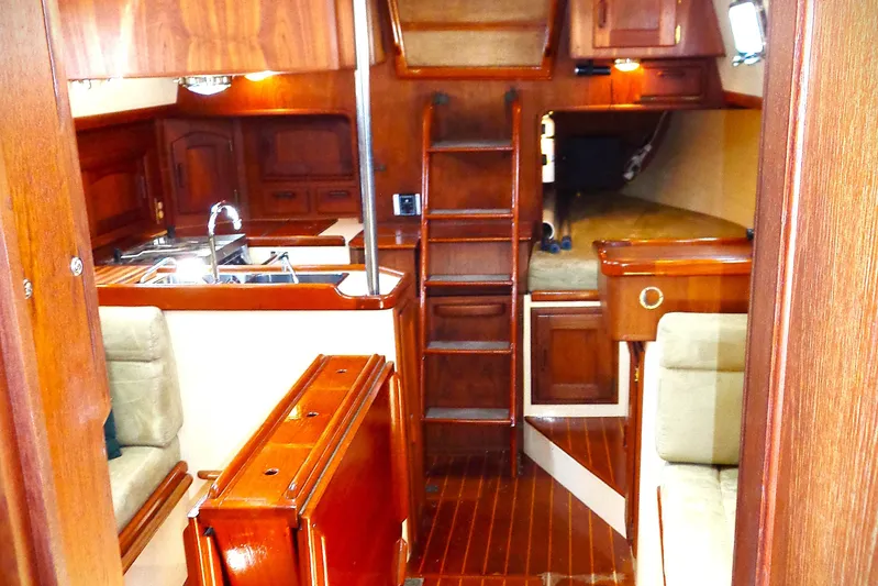 Adventure Yacht Photos Pics Interior of 1995 Pacific Seacraft 37 sailboat with wooden finishes and compact layout.