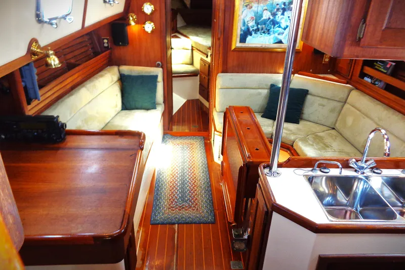 Adventure Yacht Photos Pics Interior of a 1995 Pacific Seacraft 37 yacht with cozy seating and wooden finishes.