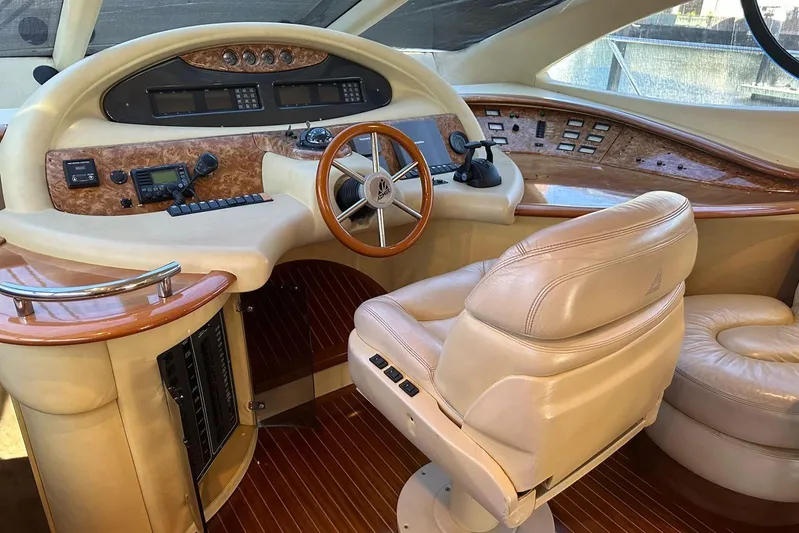 Chica Loca Yacht Photos Pics Luxurious helm of a 2003 Azimut 55E yacht with leather seating and wood accents.