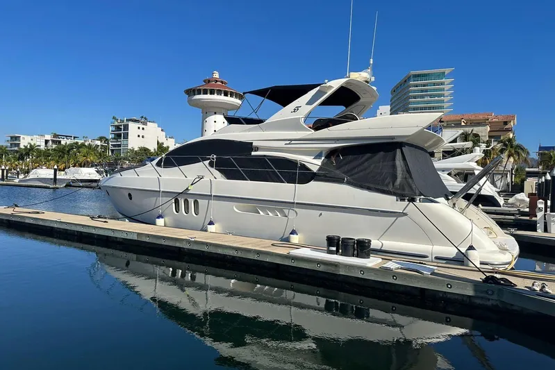 Chica Loca Yacht Photos Pics 2003 Azimut 55E yacht docked at marina, clear blue sky, modern buildings in background.