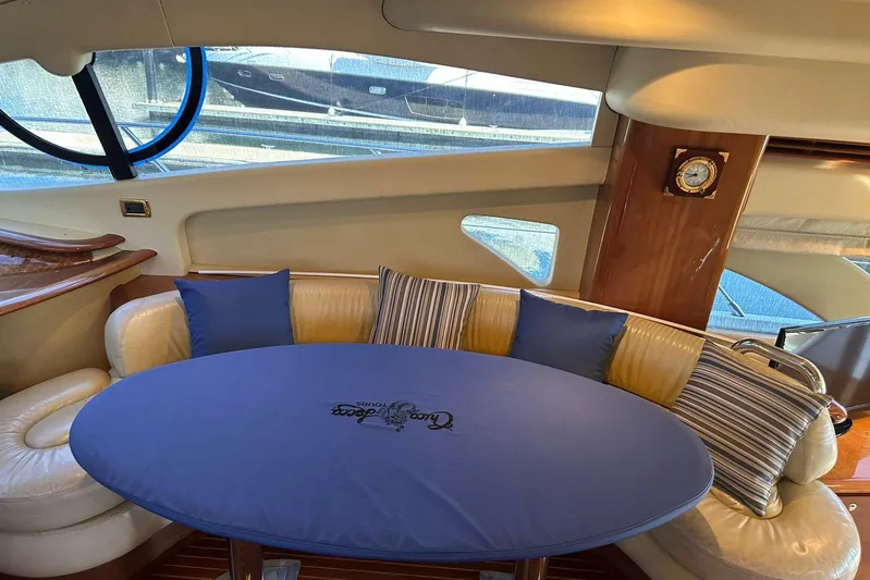 Chica Loca Yacht Photos Pics Interior of a 2003 Azimut 55E yacht with a cozy seating area and blue cushions.