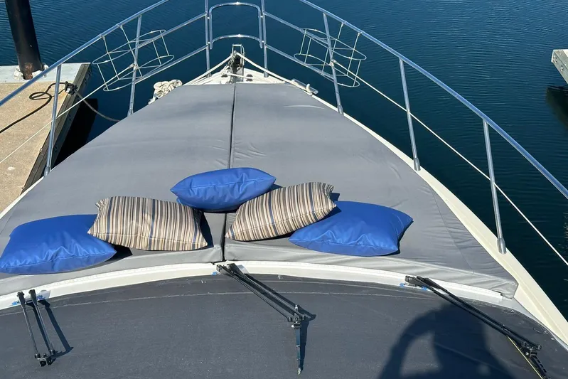 Chica Loca Yacht Photos Pics Bow of 2003 Azimut 55E yacht with cushions, docked on calm water.