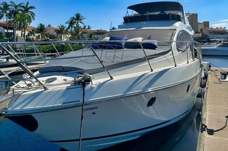 Chica Loca Yacht Photos Pics 2003 Azimut 55E yacht docked at marina, surrounded by palm trees and waterfront homes.