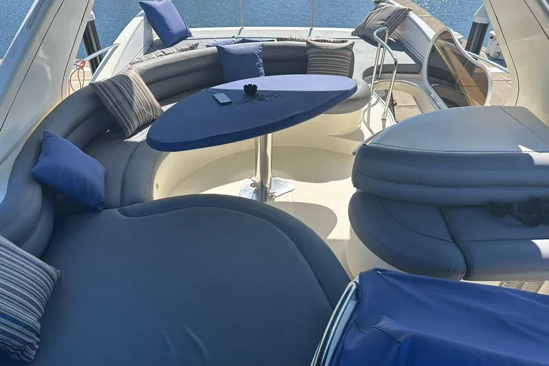 Chica Loca Yacht Photos Pics Luxurious seating area on 2003 Azimut 55E yacht with blue cushions and table.