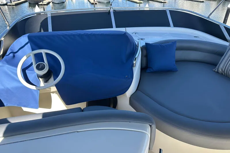 Chica Loca Yacht Photos Pics 2003 Azimut 55E yacht helm with blue cover and cushioned seating area.