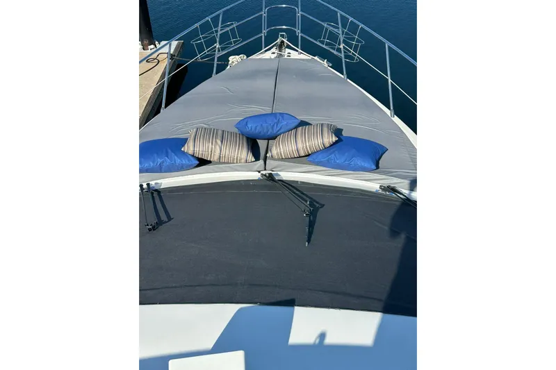 Chica Loca Yacht Photos Pics Front deck of 2003 Azimut 55E yacht with cushions, docked by the water.