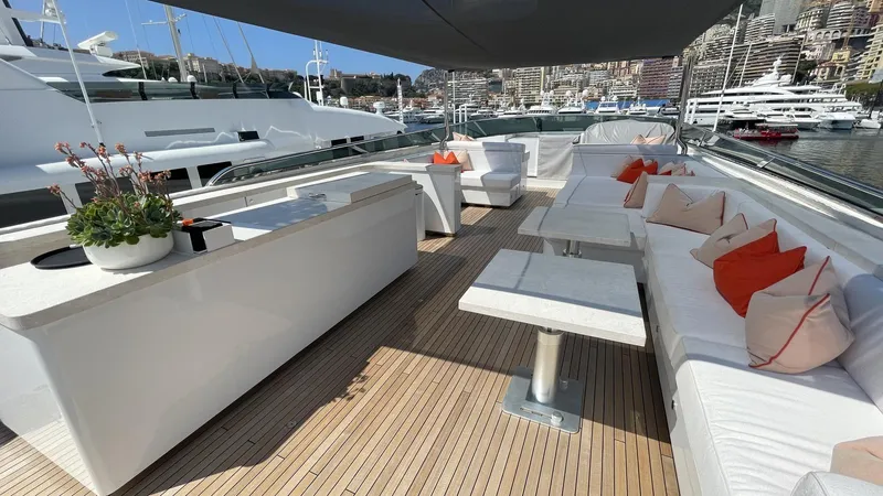 D'one Yacht Photos Pics Luxurious 2009 Leopard Yachts deck with white seating, orange cushions, and elegant wooden flooring.