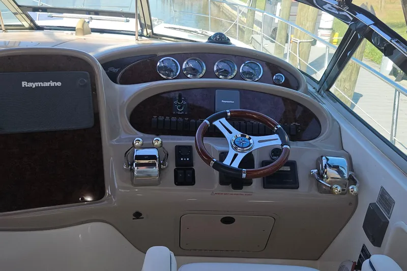 N/a Yacht Photos Pics Helm of 2004 Sea Ray 380 Sundancer with Raymarine navigation system and wooden steering wheel.
