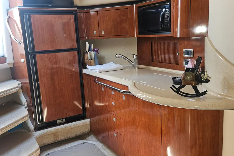 N/a Yacht Photos Pics 2004 Sea Ray 380 Sundancer yacht interior with kitchenette, featuring wood cabinetry and modern appliances.