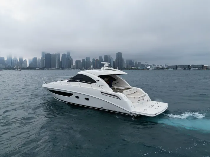 Cabby 13 Yacht Photos Pics 2013 Sea Ray 470 Sundancer yacht cruising near a city skyline under cloudy skies.