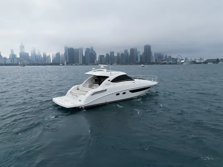 Cabby 13 Yacht Photos Pics 2013 Sea Ray 470 Sundancer yacht cruising near a city skyline on a cloudy day.