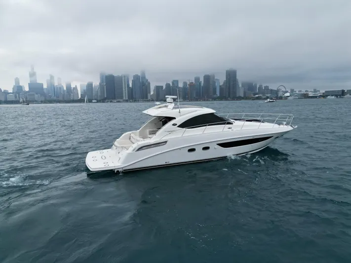 Cabby 13 Yacht Photos Pics 2013 Sea Ray 470 Sundancer yacht cruising near city skyline on a cloudy day.