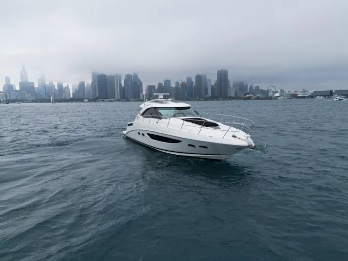 Cabby 13 Yacht Photos Pics 2013 Sea Ray 470 Sundancer yacht cruising near a city skyline on a cloudy day.