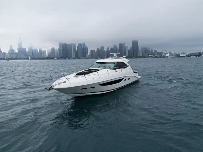 Cabby 13 Yacht Photos Pics 2013 Sea Ray 470 Sundancer yacht cruising near a city skyline on a cloudy day.