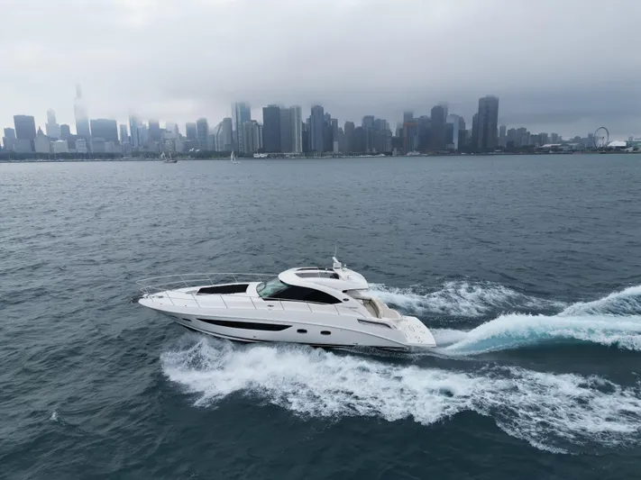 Cabby 13 Yacht Photos Pics 2013 Sea Ray 470 Sundancer cruising on water with city skyline in background.