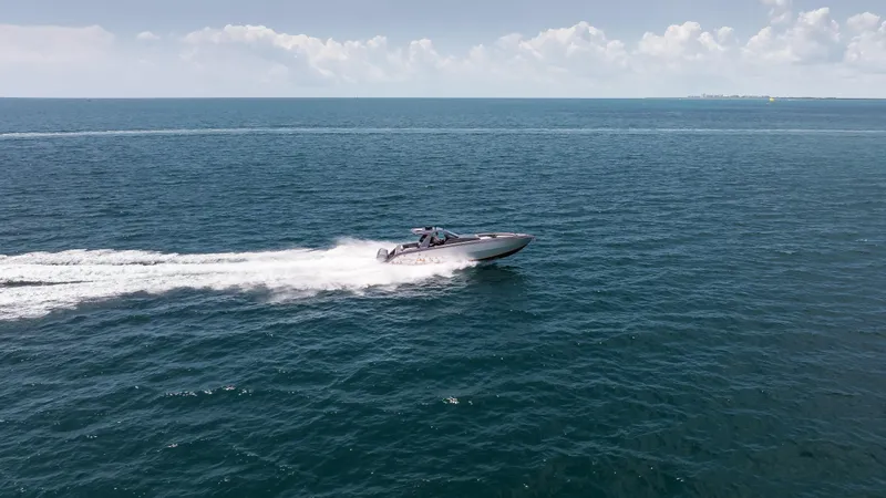  Yacht Photos Pics 2025 Cigarette 42 Auroris speedboat cruising on open ocean under clear sky.
