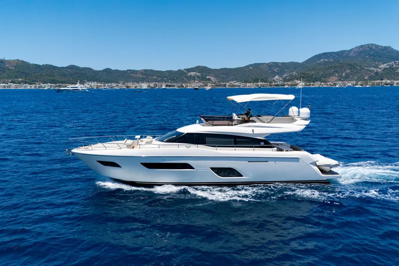 Dudu Yacht Photos Pics 2021 Ferretti Yachts 550 cruising on blue ocean with scenic mountain backdrop.