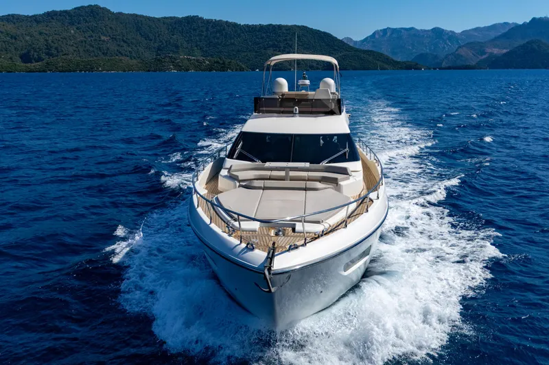 Dudu Yacht Photos Pics 2021 Ferretti Yachts 550 cruising on blue ocean with scenic mountain backdrop.