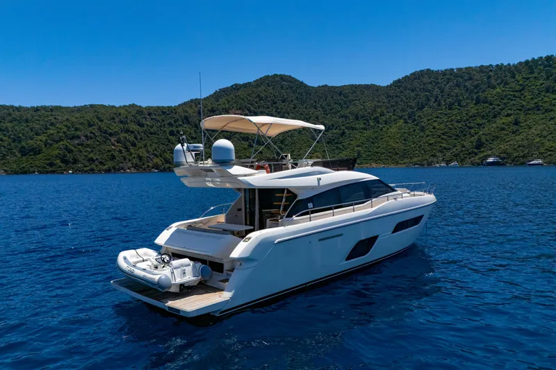 Dudu Yacht Photos Pics 2021 Ferretti Yachts 550 cruising on blue waters with lush green hills in the background.