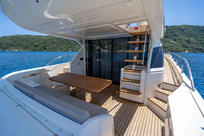 Dudu Yacht Photos Pics Luxurious 2021 Ferretti Yachts 550 deck with seating, table, and scenic ocean view.