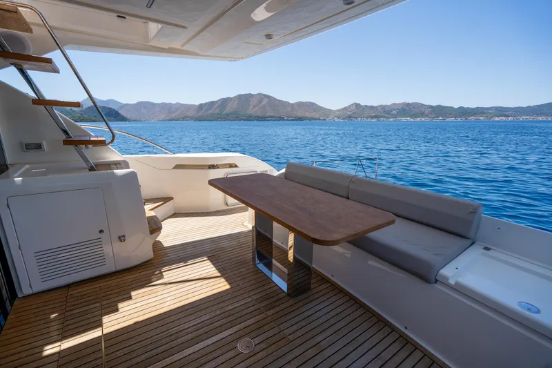 Dudu Yacht Photos Pics Luxurious 2021 Ferretti Yachts 550 deck with seating, table, and scenic ocean view.