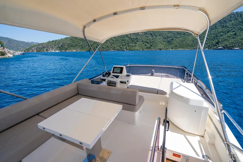 Dudu Yacht Photos Pics Flybridge of 2021 Ferretti Yachts 550, featuring seating and navigation controls, overlooking scenic waters.