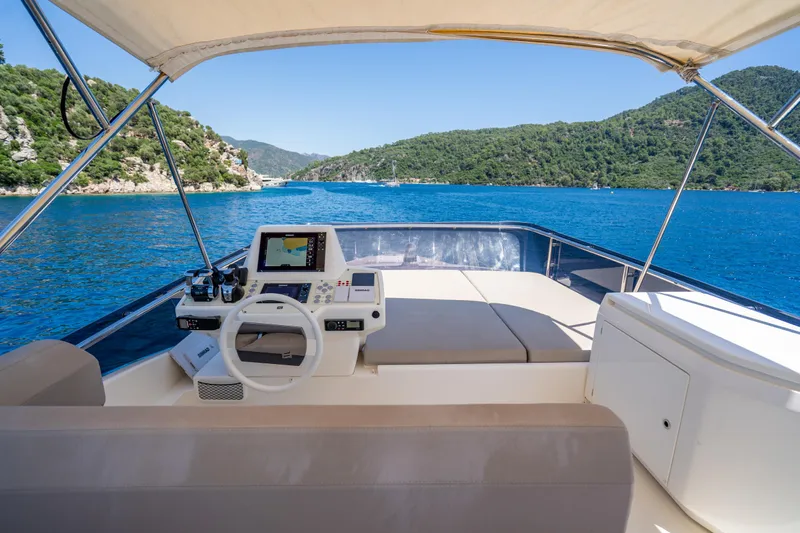 Dudu Yacht Photos Pics 2021 Ferretti Yachts 550 helm with scenic ocean view and lush green hills.