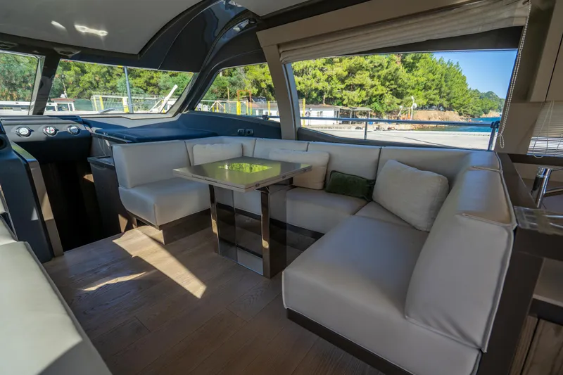 Dudu Yacht Photos Pics Luxurious interior of 2021 Ferretti Yachts 550 with elegant seating and scenic window view.