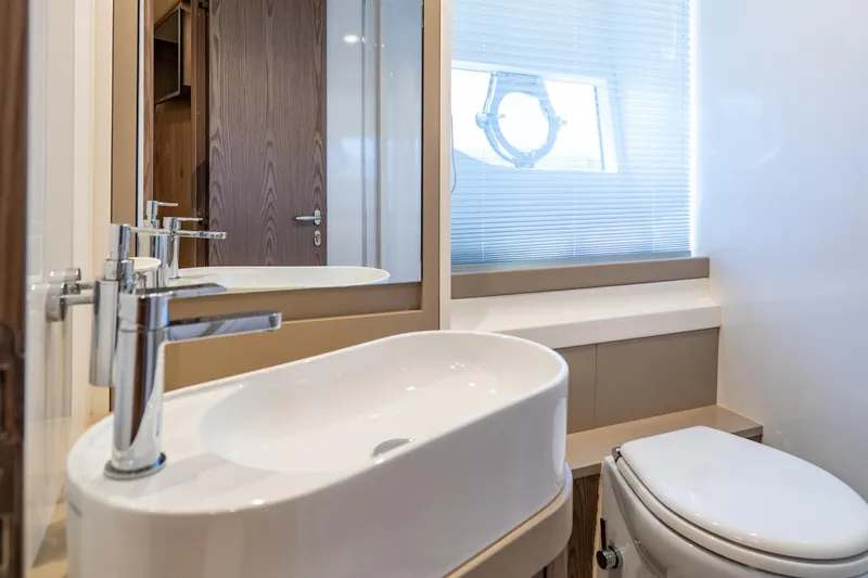 Dudu Yacht Photos Pics Luxurious bathroom interior of 2021 Ferretti Yachts 550 with modern sink and toilet.