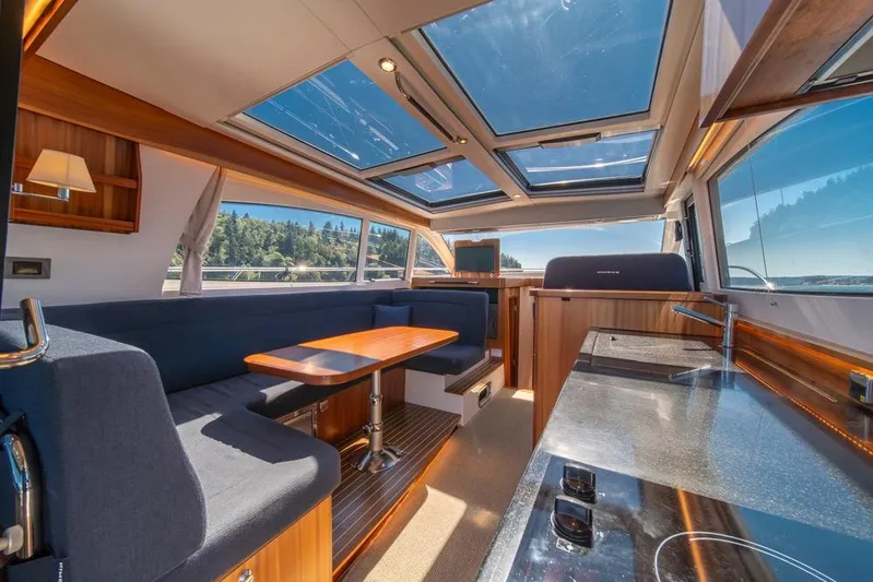 Treasure State Yacht Photos Pics Luxurious interior of 2022 Nimbus 405 Coup&eacute; yacht with panoramic windows and modern furnishings.