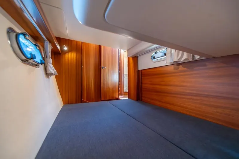 Treasure State Yacht Photos Pics Interior cabin of 2022 Nimbus 405 Coup&eacute; with wooden paneling and porthole windows.