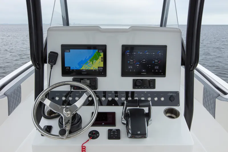  Yacht Photos Pics 2024 Streamline 26 CC boat dashboard with navigation screens and steering wheel on open water.