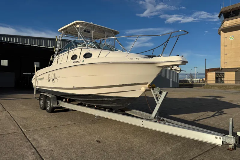  Yacht Photos Pics 2009 Wellcraft 270 Coastal O/B boat on trailer, parked outdoors under clear sky.