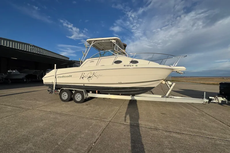  Yacht Photos Pics 2009 Wellcraft 270 Coastal O/B boat on trailer, parked outdoors under a clear sky.