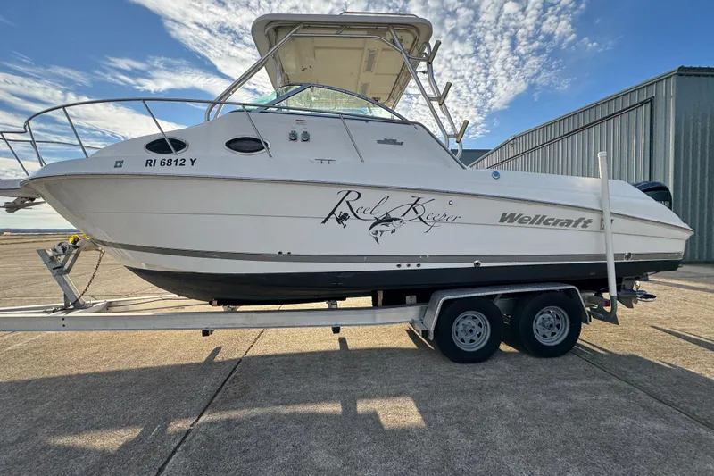 Yacht Photos Pics 2009 Wellcraft 270 Coastal O/B boat on trailer, parked outdoors under a blue sky.